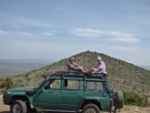 The Coopers survey the terrain from the top of their hosts' four-wheel drive vehicle